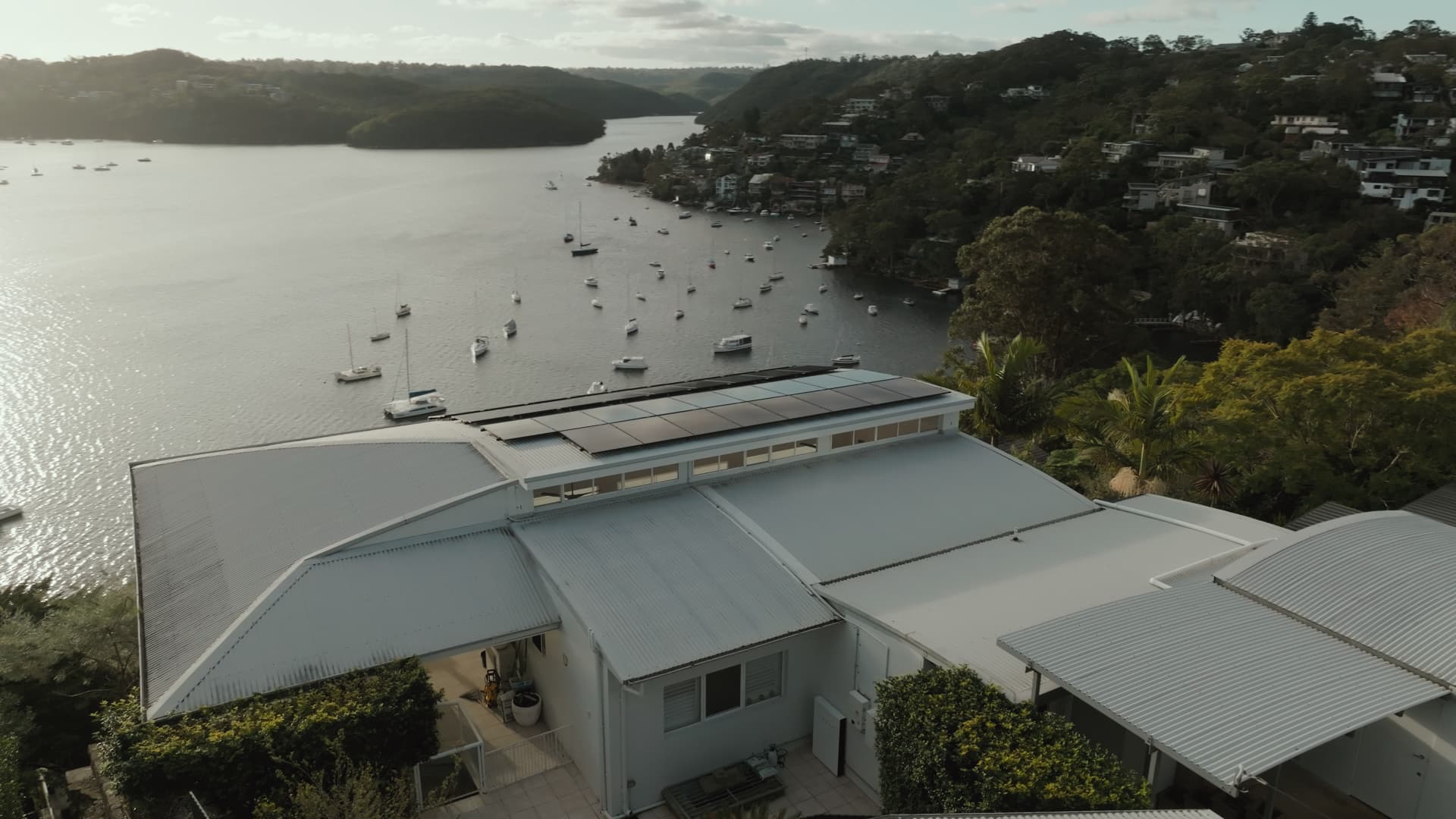 Aerial view of a Sydney beach and headland with residential rooftops